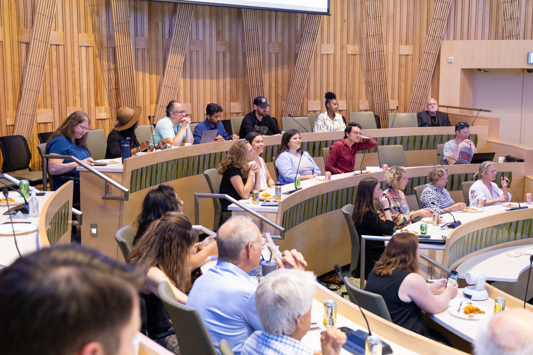 Onesideoftheaudienceinacircularroomlookingtothecenteroftheroomwherethespeakerislocated