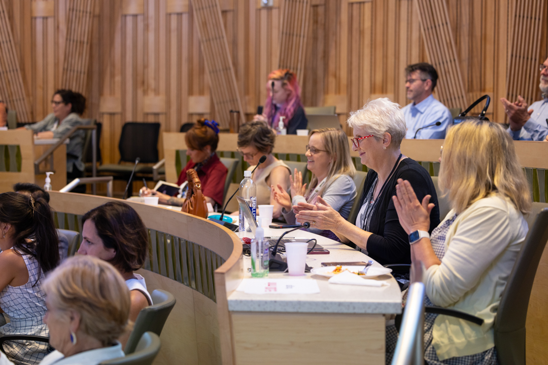 Audiencemembersintheirseatsclappingfortheguestspeakers