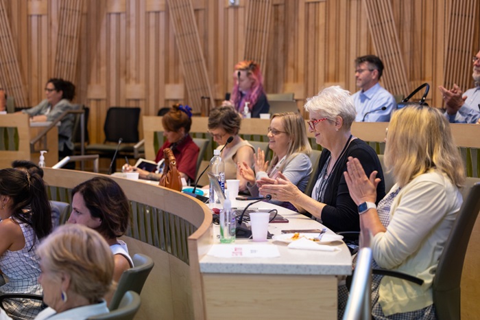 Audiencemembersintheirseatsclappingfortheguestspeakers