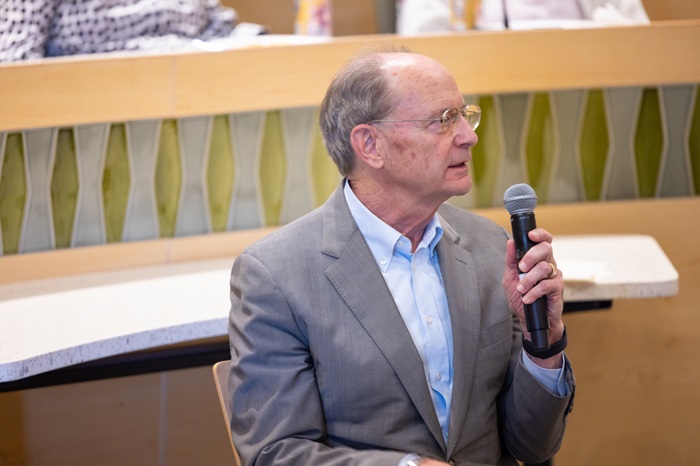 DonRugglesholdingamicrophoneashemoderatesapaneldiscussion