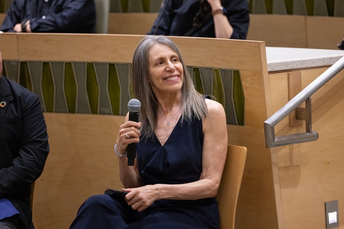 NanEllinholdingamicrophoneasshespeaksonapanel