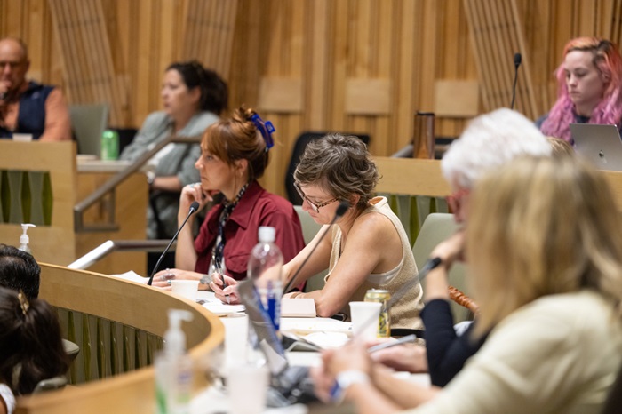 Audiencememberslookingforwardlisteningtoresponsesfrompanelists