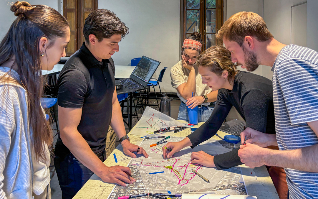 Five students stand over a map.