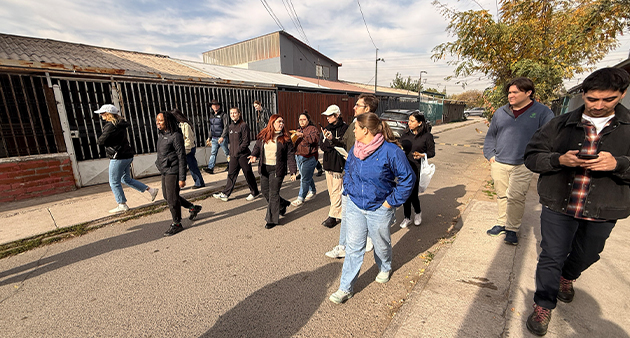 Students walk down a road in Chile talking to one another.