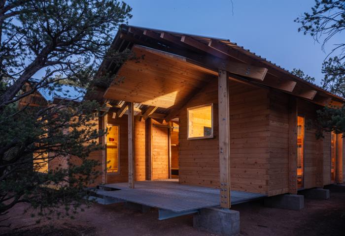 Cabin exterior at night with lights on inside