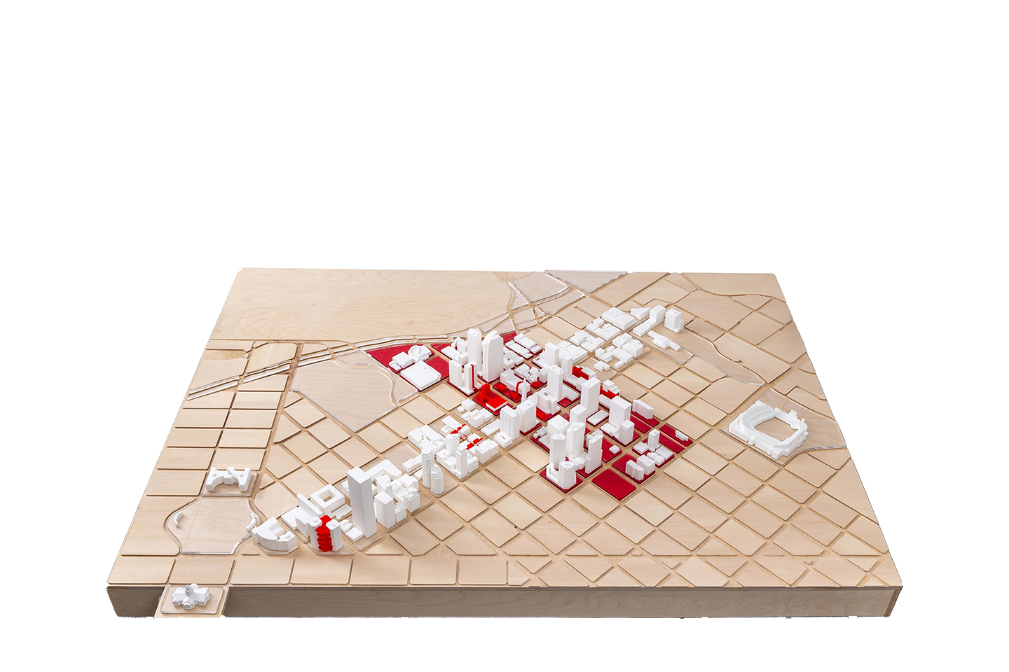 A wooden topographical board with white 3D printed buildings and red squares placed to outline a section of a city. 