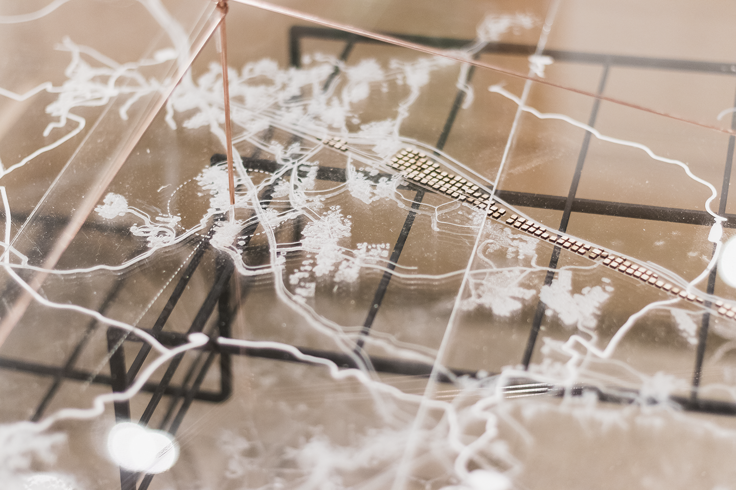 A closeup of the small details in the topographical map with a plexiglass cover and white lines.