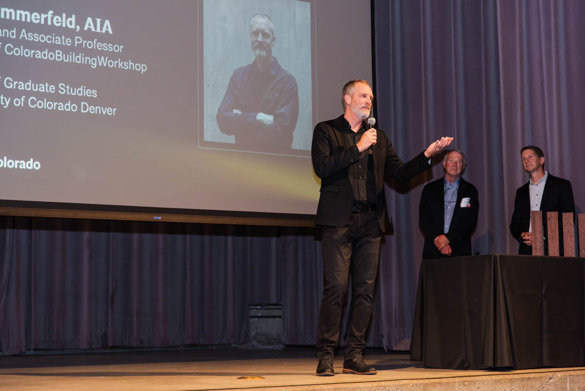 Rick Sommerfeld on stage speaking into a microphone.