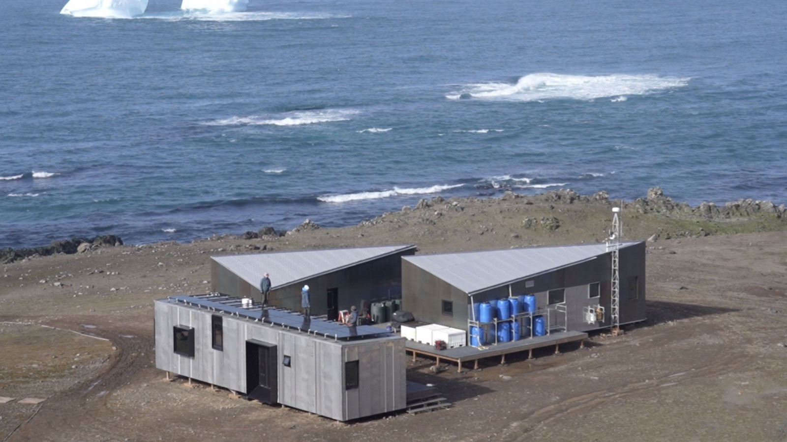 Exterior of the Holt Watters Field Camp on site in Antarctica overlooking the ocean and mountains.