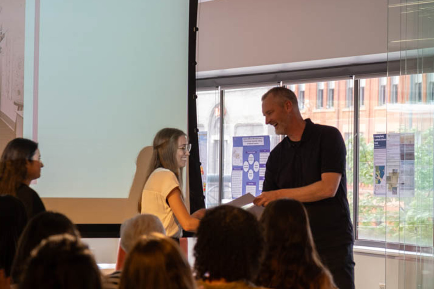 Rick Sommerfeld hands architeture studio award to students at the 2026 Spring Celebration and Awards.