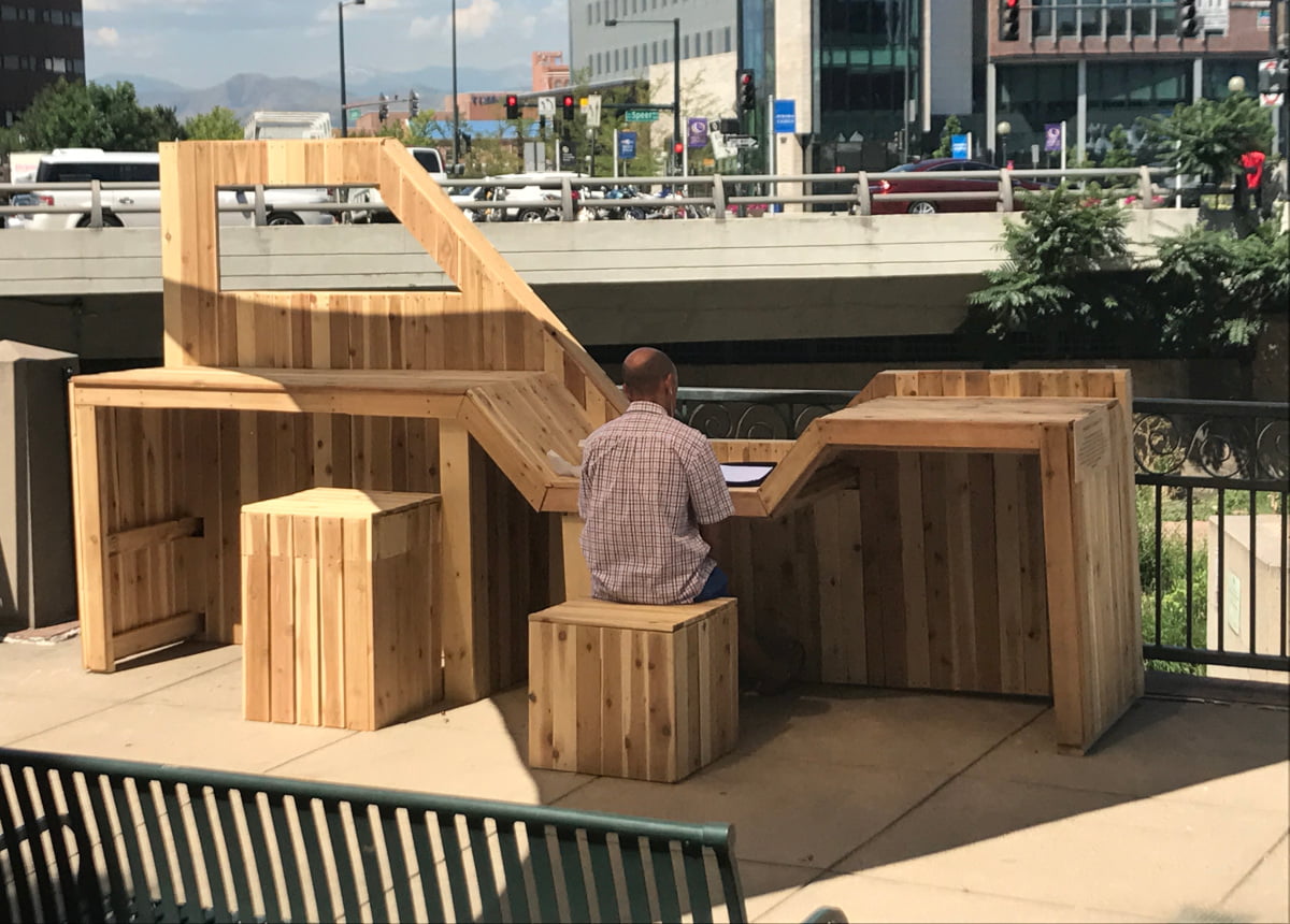 man working at a desk outside in the city
