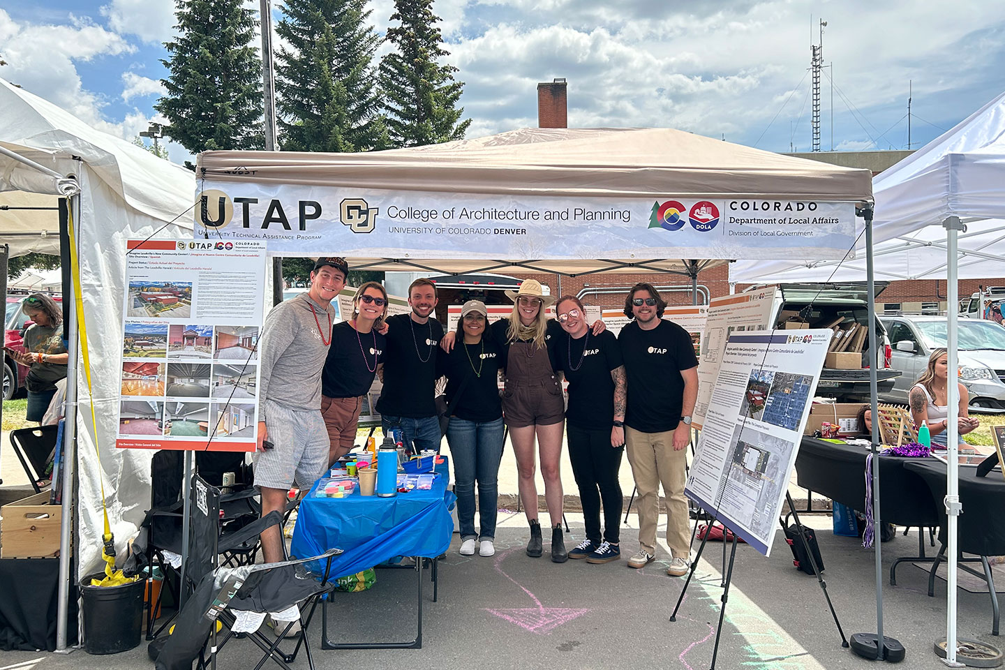 UTAP Team standing together under a tent at a community engagement event.