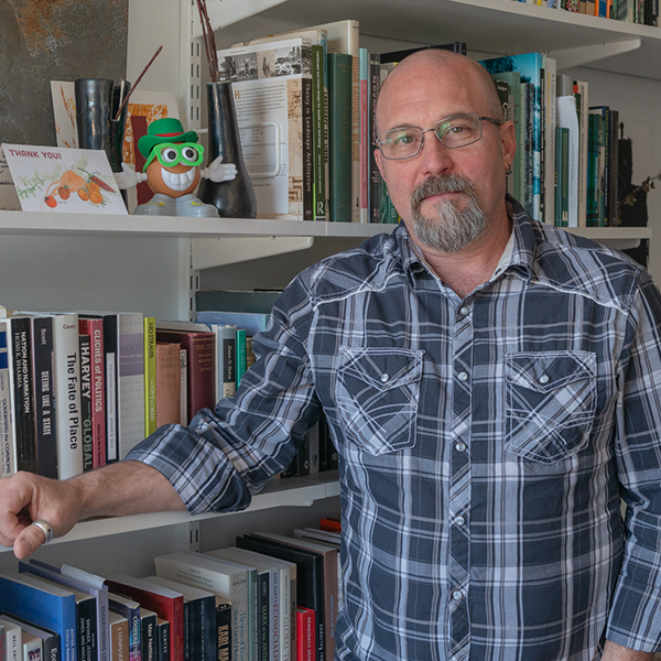 Jody Beck standing in his office beside a bookshelf.