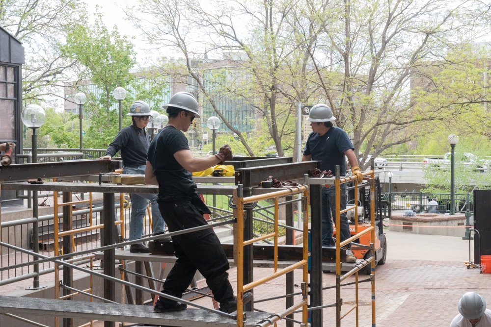 Three students constructing kiosks at CU Denver.