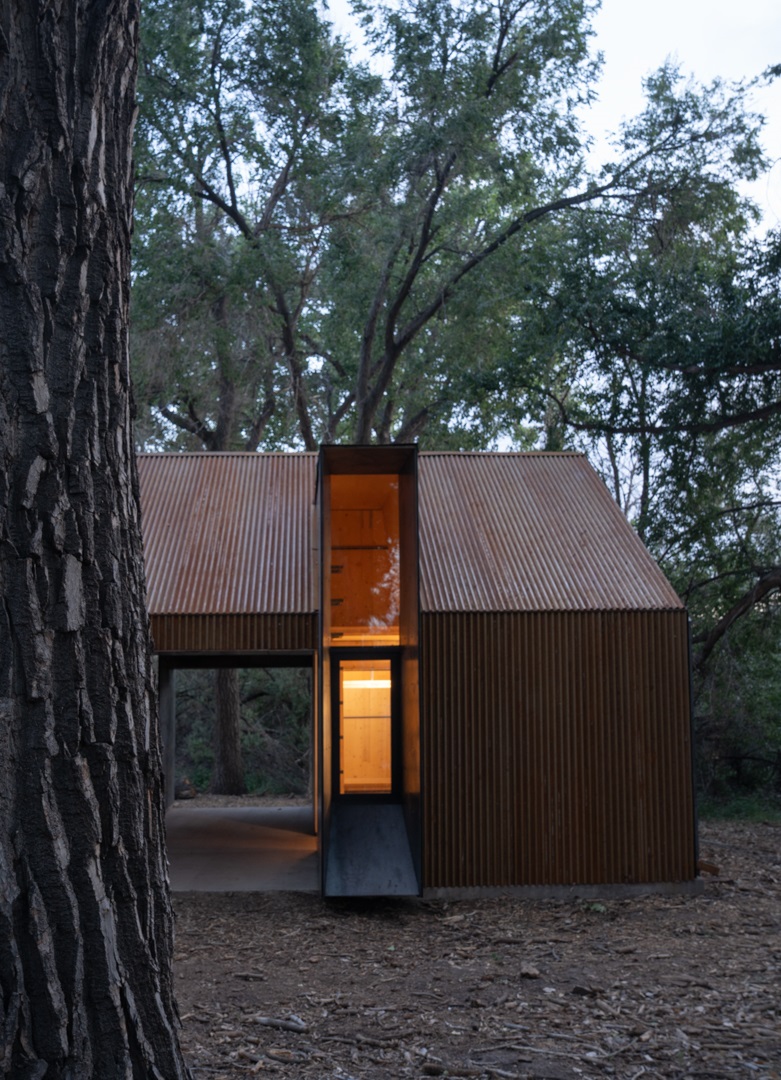 Exterior of the Aiken Audubon Research Outpost focused on the open entry in the evening.
