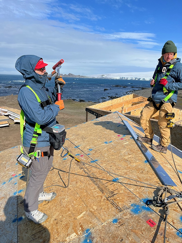 Two team members standing on the platform, beginning construction on the research lab site.